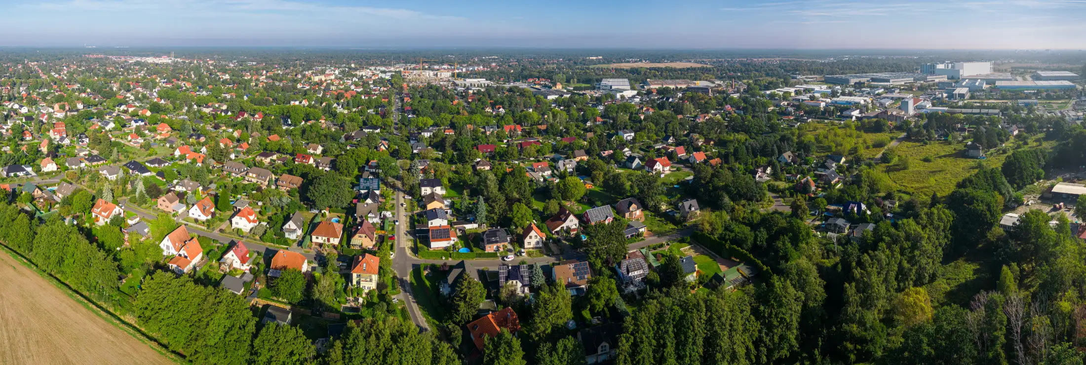 Luftaufnahme – Panorama von Falkensee (aufgenommen am Südrand, Blickrichtung Norden): vorne die Immobilien an der Dallgower Str. und Oskar-von-Miller Str., dahinter die Innenstadt von Falkensee, rechts Seegefeld und Gewerbegebiet-Süd, dahinter Falkenhagen